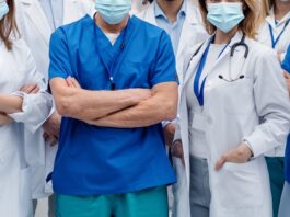 group of doctors with face masks looking at camera, corona virus concept.