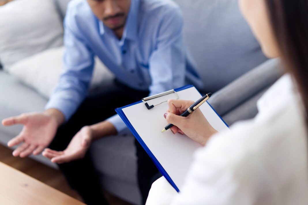 young male patient sitting on sofa explaining and consulting his